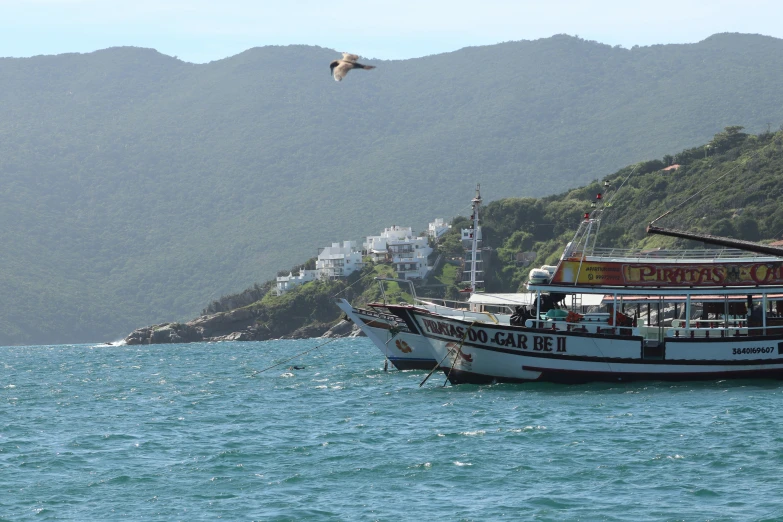 the boat is docked in the water by the mountains