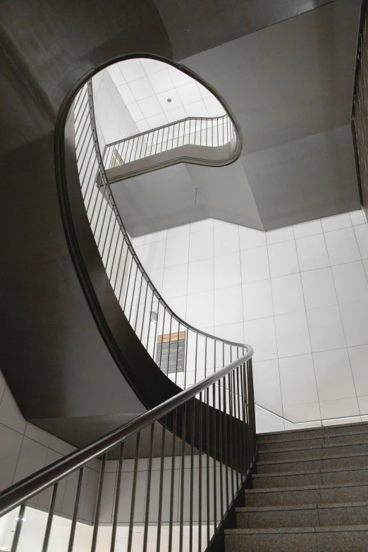 a metal spiral staircase with two people on the ground