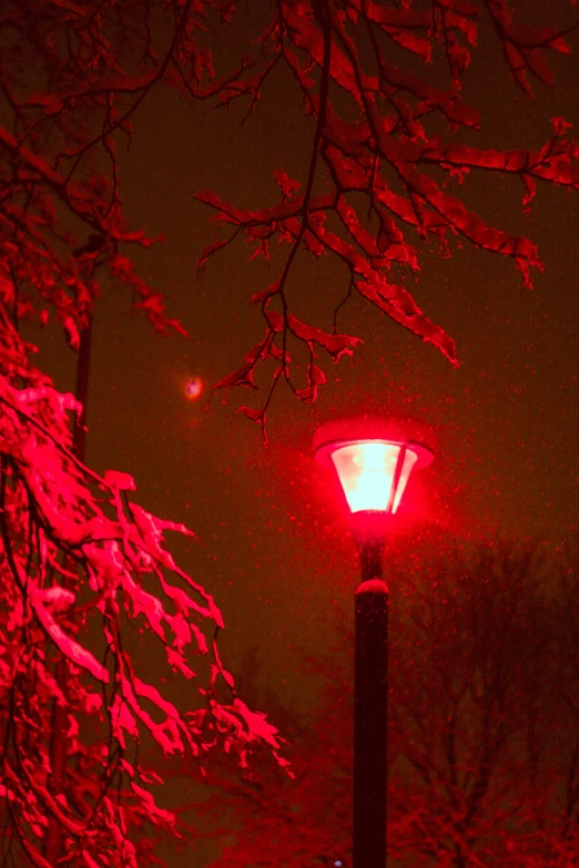 a lamp post covered in snow under a dark sky