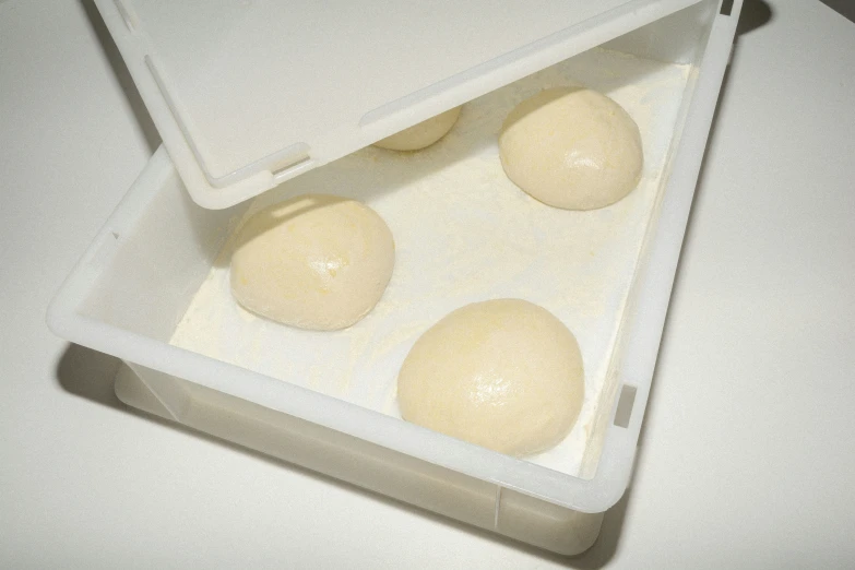 three dough balls in a baking pan