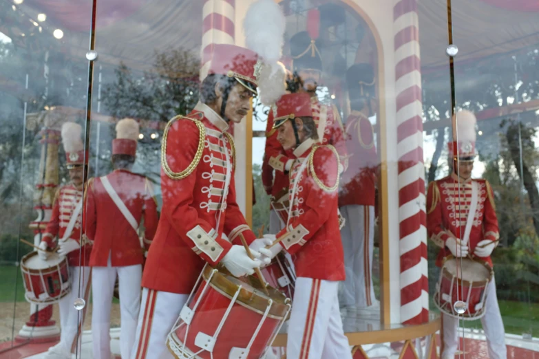 some men in red military uniforms are near a window