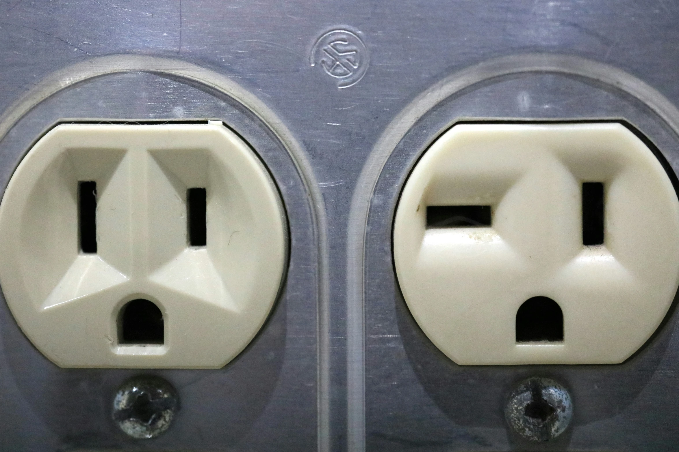 two identical electrical outlets, one white and one silver