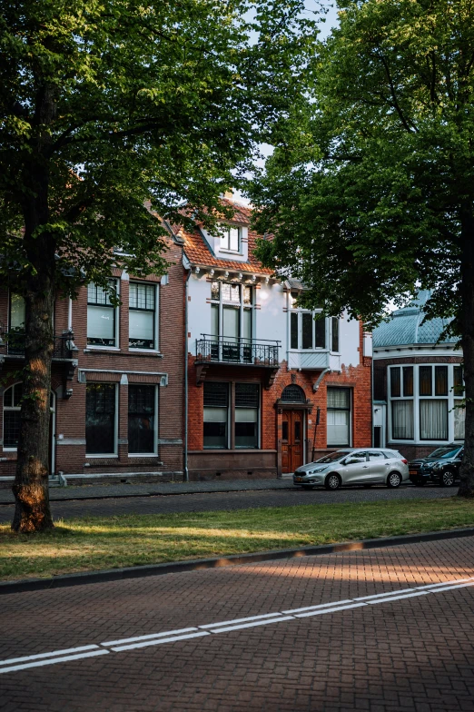 a white car parked next to some trees and buildings