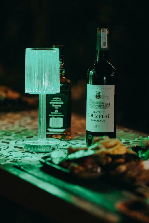 food is placed on a plate with two bottles of wine behind it