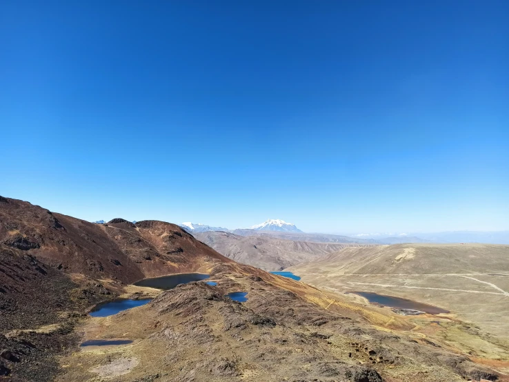 an airplane flying over some large hills near water