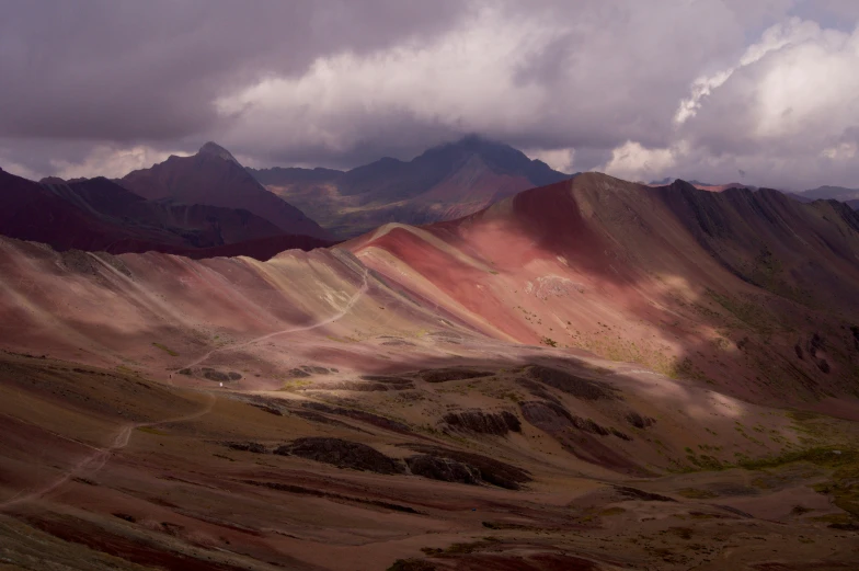 a mountain range covered in different shades of pink, green and orange