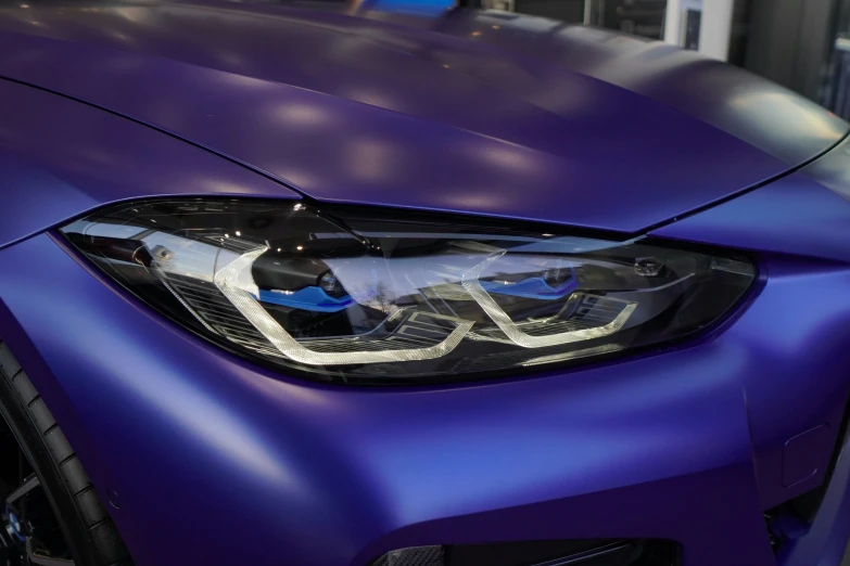 the front end of a purple car with headlights