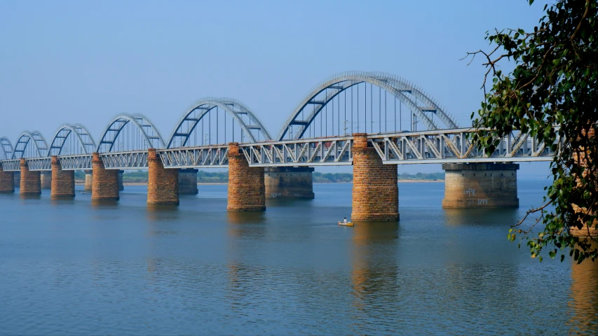 a large bridge crosses the water under a blue sky