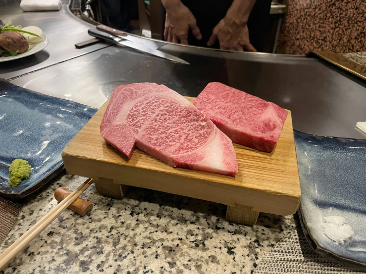 some pieces of raw tuna on wooden planks