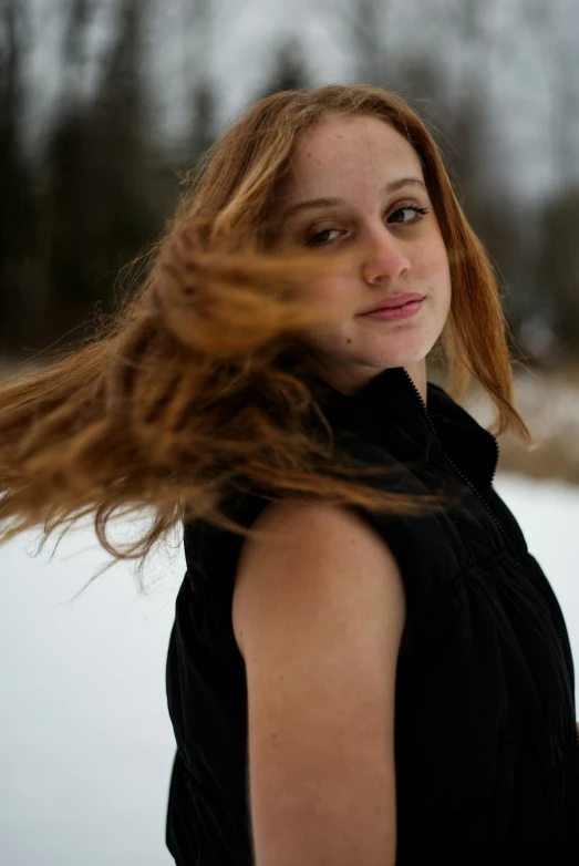 a woman's red hair blows in the wind