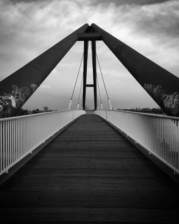 a pedestrian bridge with lots of graffiti on it