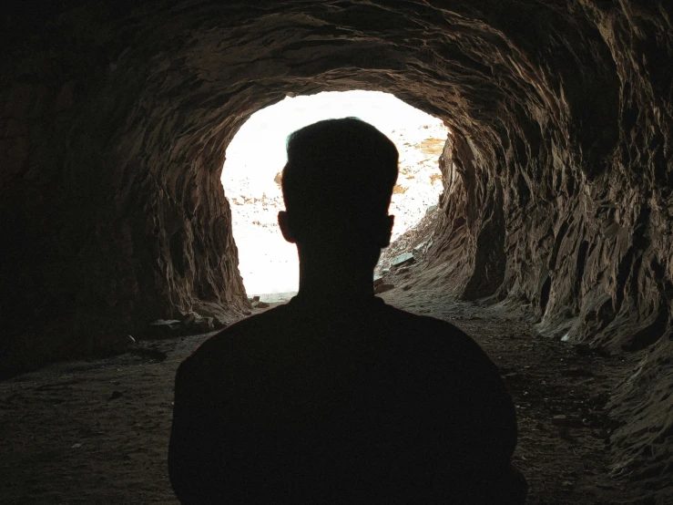 a man is looking out in a very narrow tunnel