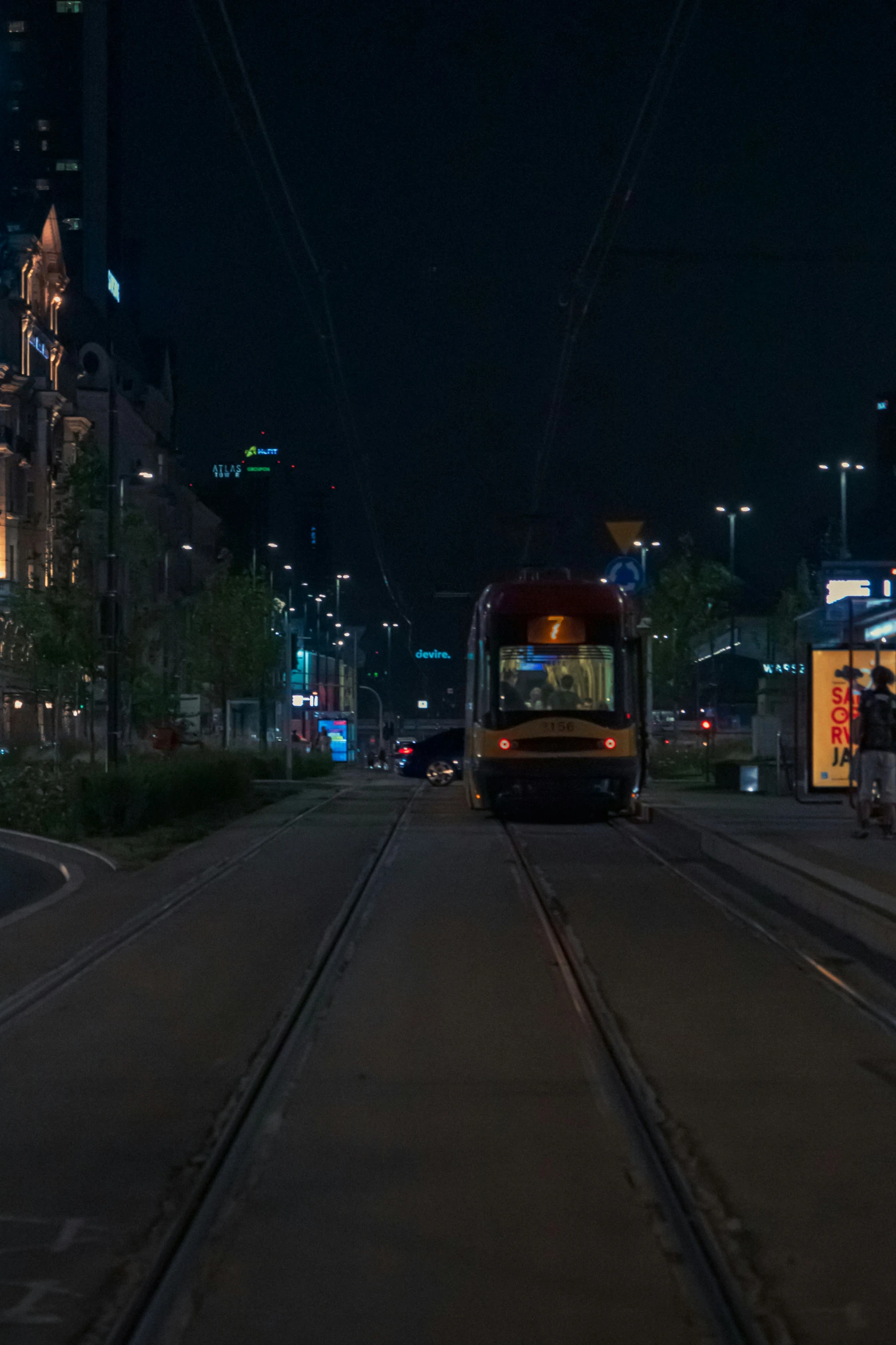 a city bus is traveling down the street at night