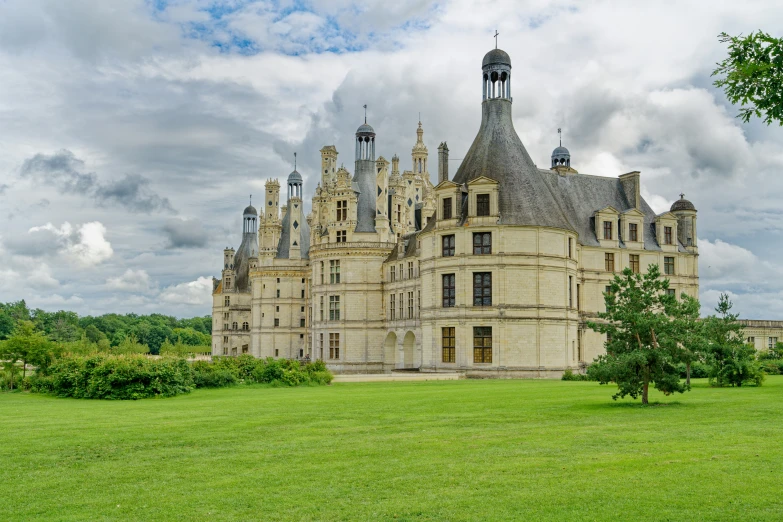 an ornate building with turrets sits on grass