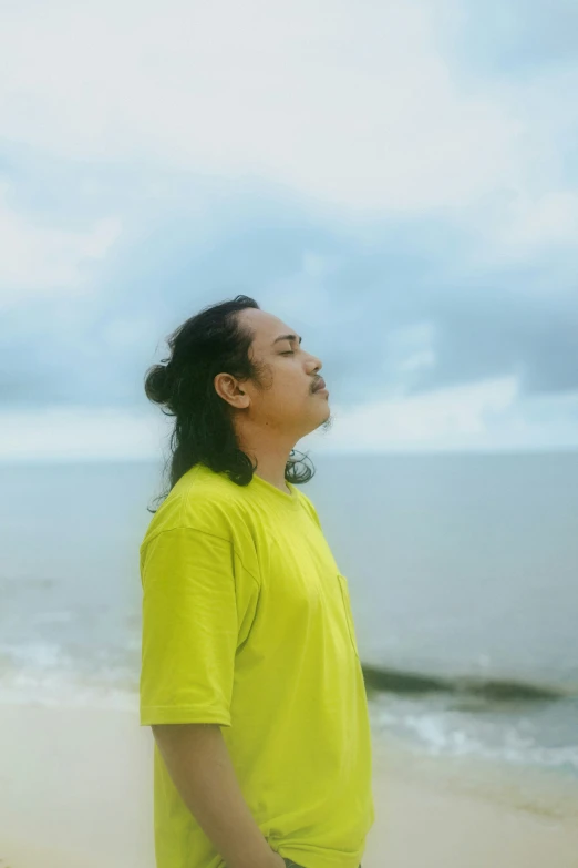 the woman is looking up at the sky on the beach