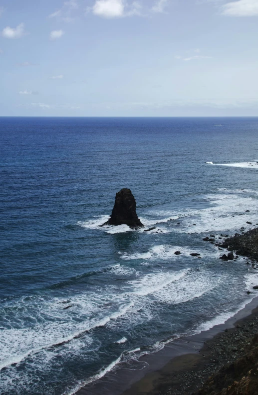 view of the coast near a mountain on a sunny day