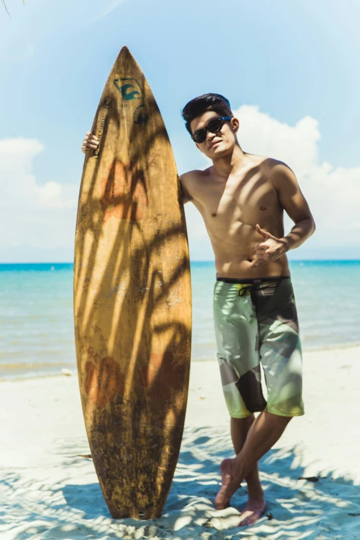 man standing on the beach with his surf board