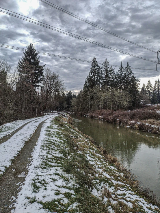 snow covers the ground next to a creek