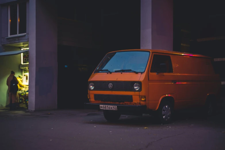 an orange van is parked in front of some buildings