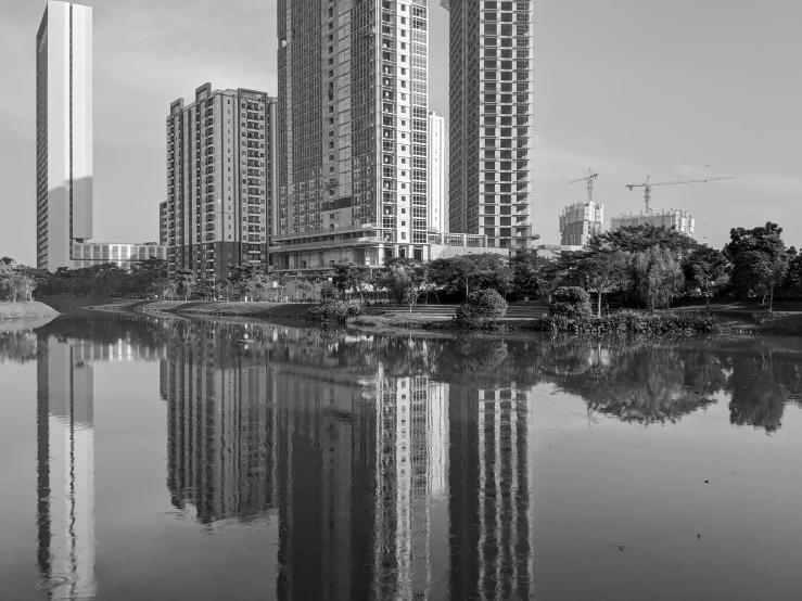 two buildings reflecting in the water and a few trees