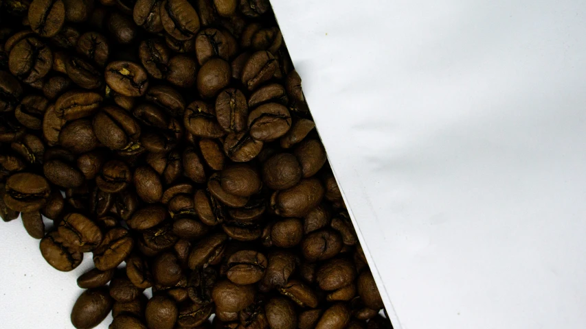 a pile of coffee beans in the middle of a white table