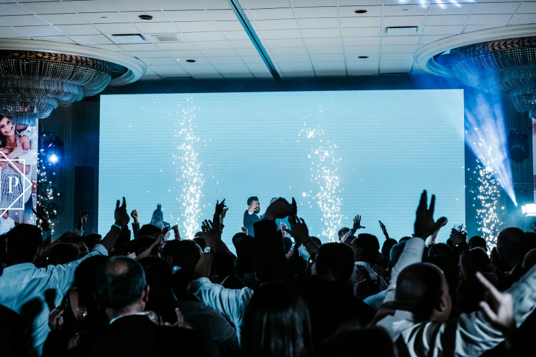 a huge crowd is watching a man perform on stage