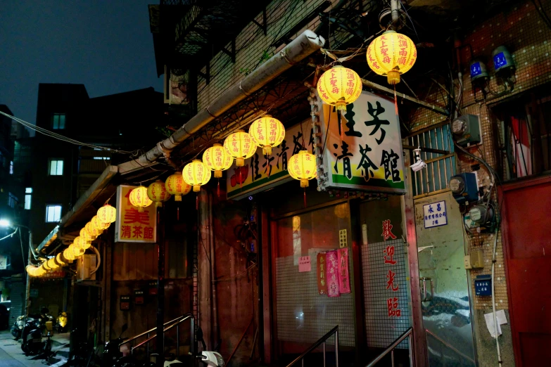 oriental lantern lights are lit on an urban street at night