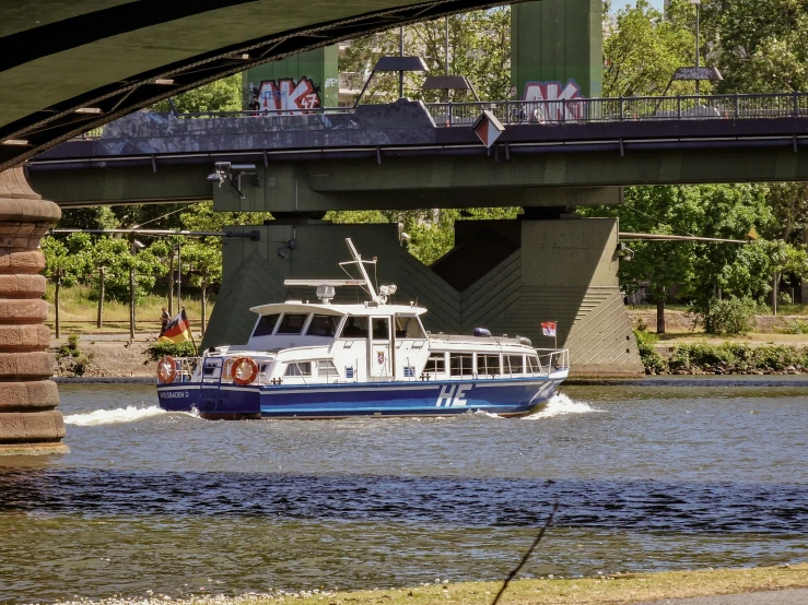 a boat is in the water going under a bridge