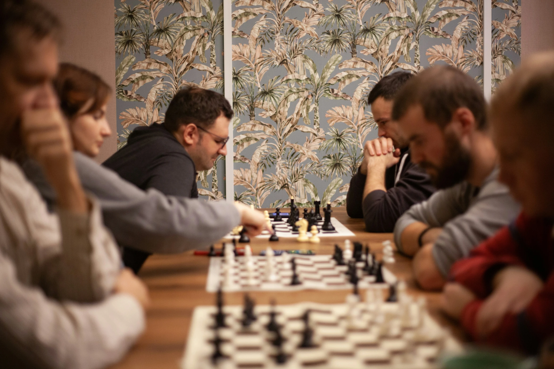 a group of people playing chess in front of a wall