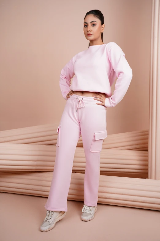 a young woman poses for a pograph wearing a pink sweatshirt and matching sweatpants