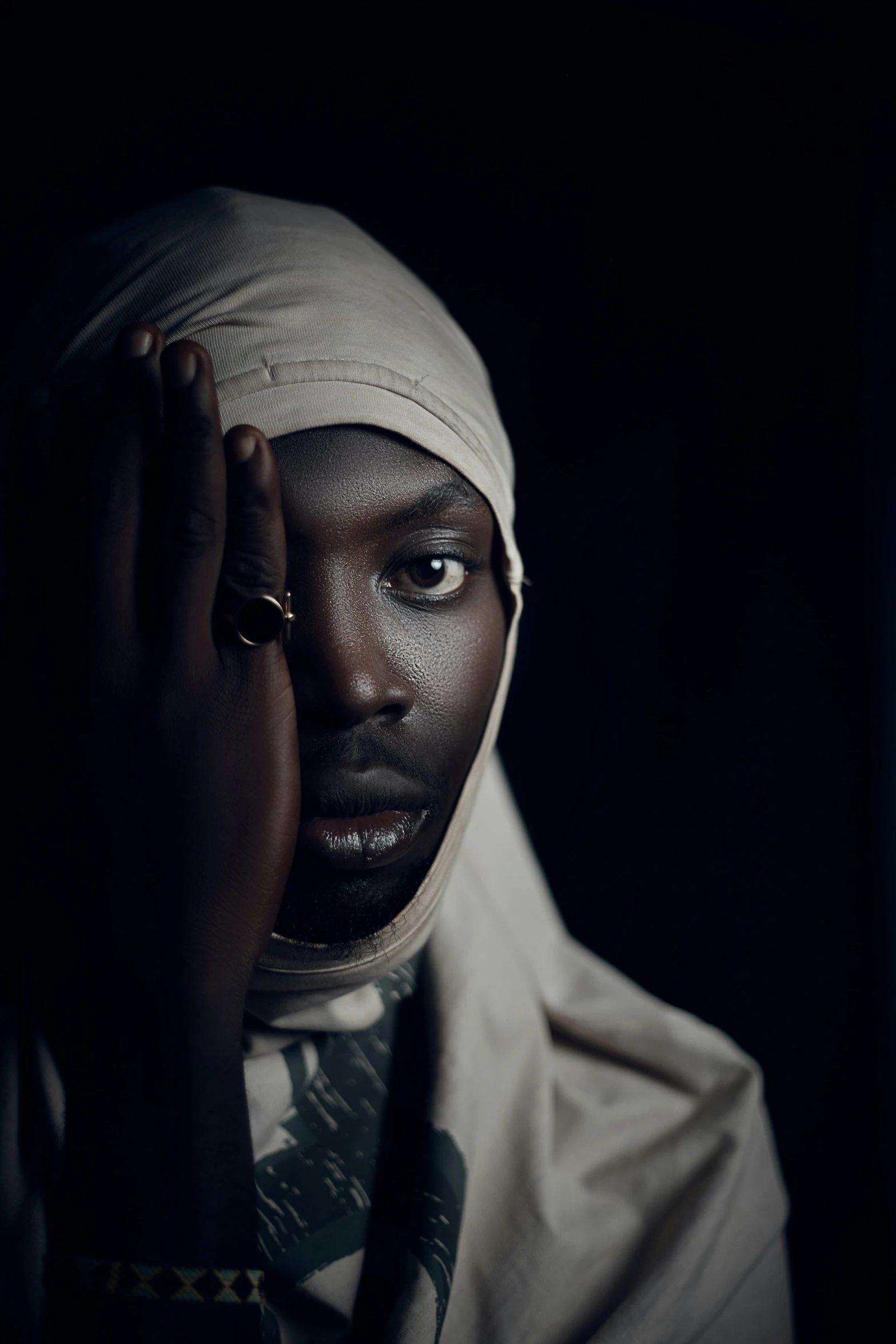 woman holding hands on her head in dark