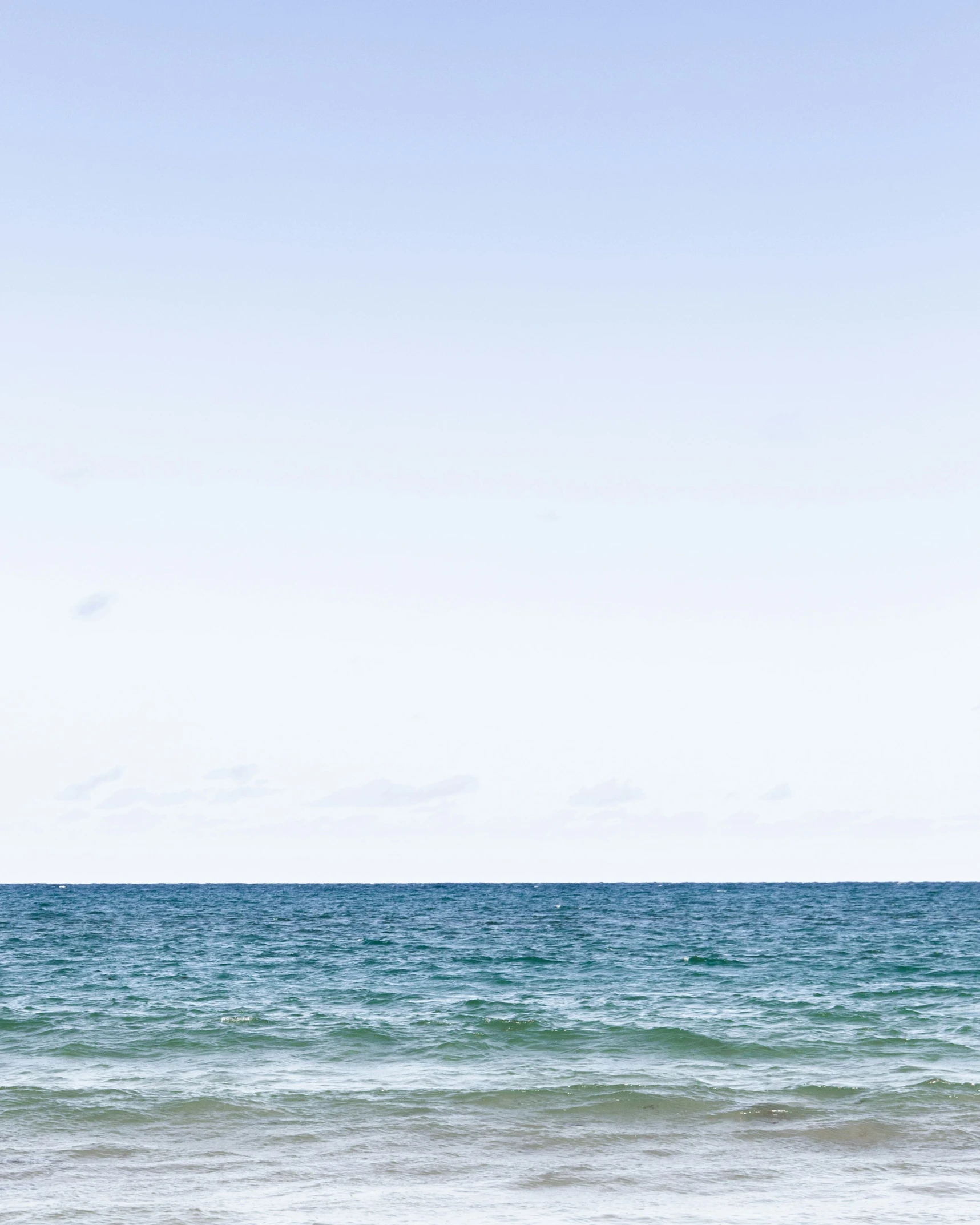 a person on the beach holding a surf board