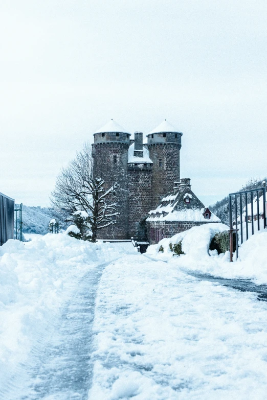 snow covered road leading to large building in snowy area