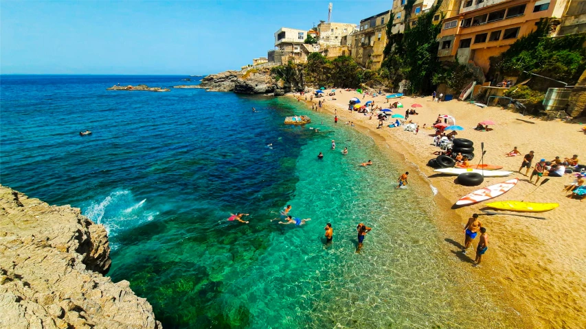 a beautiful ocean and beach with people sunbathing