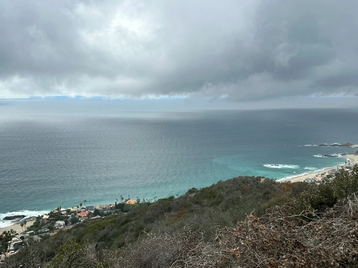 a beach next to a body of water under a dark cloudy sky