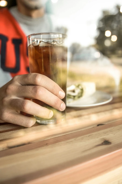 a man that is sitting at a table with some drinks