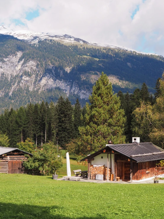 a hut in front of some mountains is shown