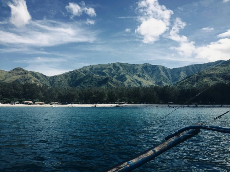 a boat is on the water with mountains in the background