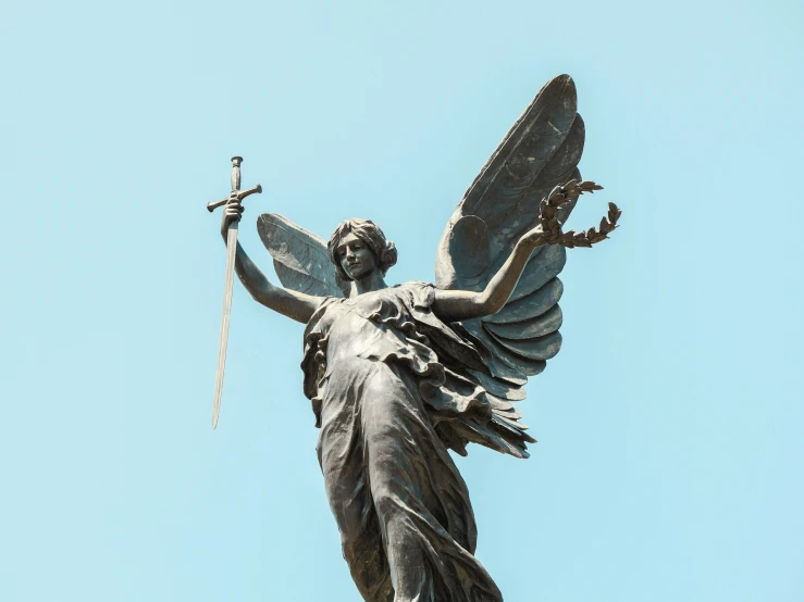 a statue of a winged angel holding two swords