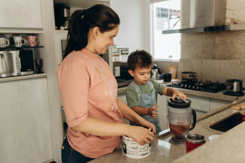 a woman is standing in front of a child making soing