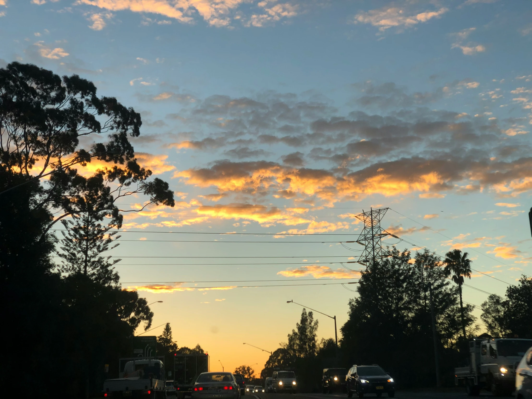 a sunset s of the streets with cars driving down it