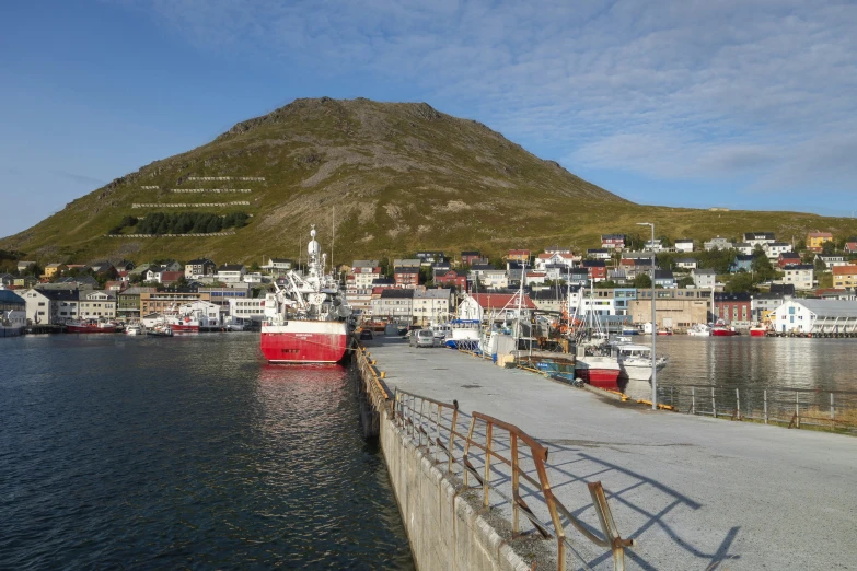 a very large mountain behind some harbor with lots of boats