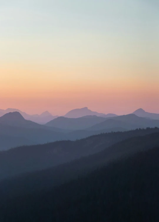 the mountains at sunrise are filled with pink clouds