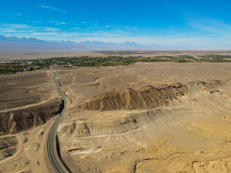 aerial view of winding desert highway and mountains in the background