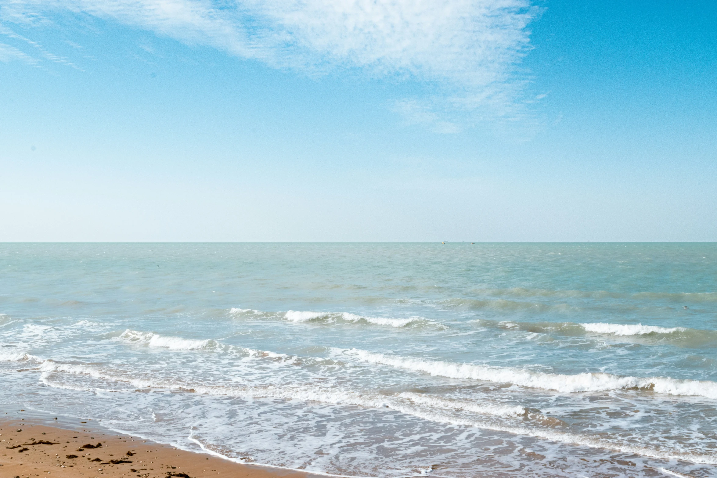 the blue sky above the water shows that we are a bit smaller than those white, fluffy waves