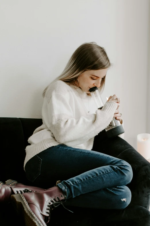 a woman sitting on top of a couch while wearing boots