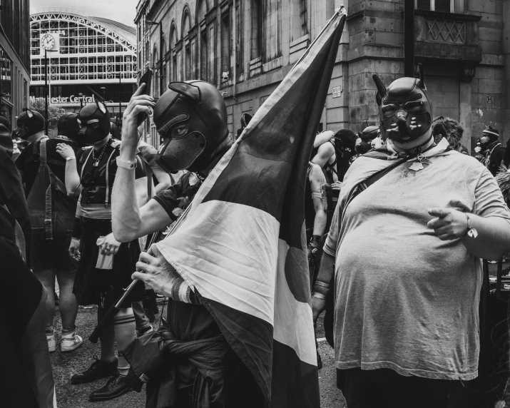 a group of people in costumes and masks marching in the street