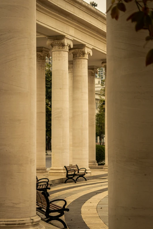 a sidewalk lined with pillars and benches