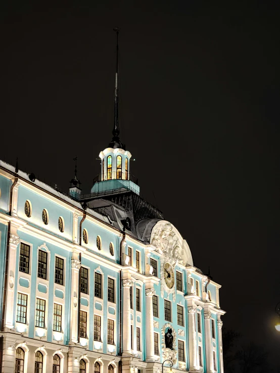 a blue and white building lit up at night