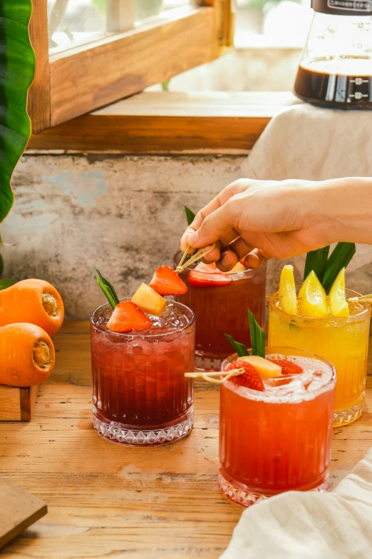 several cocktails with a person decorating them